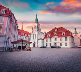 Beautiful autumn dawn in Riga. Amazing morning view of Our Lady of Sorrows Catholic Church, Riga. Empty square in center of old town of capital of Latvia, Europe. Traveling concept background..