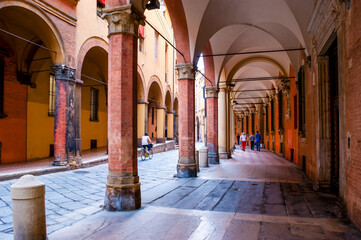 Via Castiglione curved street with porticos, the covered arcades-walkways, Bologna, Italy © efesenko