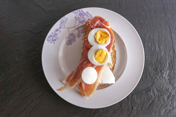 Sandwiches with ham, cheese and egg on a white plate