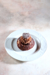 A pastry with custard cream. French Shu cake with peach jam. A modern dessert.