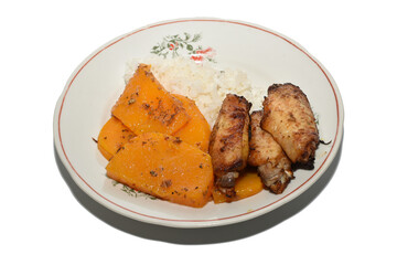 Breakfast on a plate. Rice, stewed pumpkin pieces and grilled chicken wings.