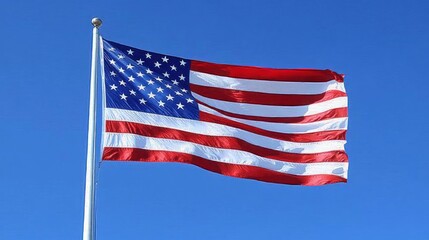 Obraz premium The American flag waving proudly against a clear blue sky.