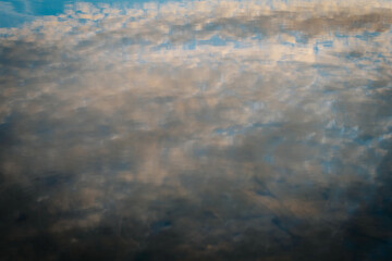 An abstract image capturing a soft, watery, blurred view of clouds in the sky. The defocused effect creates a dreamy, atmospheric scene, emphasizing texture and mood over clarity.