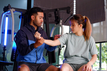 Young woman and trainer working out in a gym.