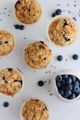 Homemade blueberry muffins with almond crumble and lavender, top view close-up on white background, fresh berries, lavender flowers