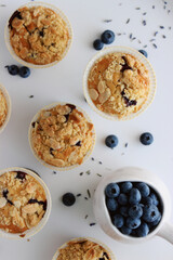 Homemade blueberry muffins with almond crumble and lavender, top view close-up on white background, fresh berries, lavender flowers