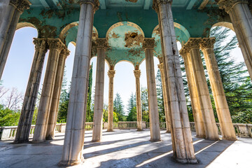 Columns in abandoned Medea sanatorium in Tskaltubo, Georgia. Sunlight shines through tall pillars,...