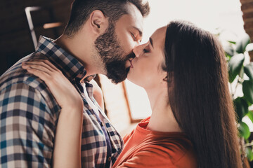 Naklejka premium Photo of attractive trendy cheerful gentle kiss married young couple spending free time move new apartment home interior indoors