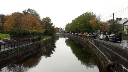 The grand canal in Dublin, Ireland, on a cloudy overcast day, the trees reflecting in the water
