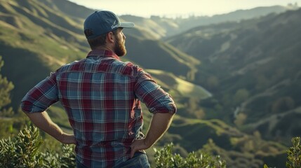 Naklejka premium A man gazes over a lush valley, reflecting on nature's beauty and serenity.