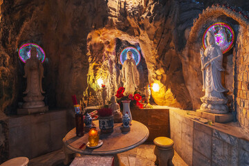 Buddhist temple with statues and sanctuary inside the Am Phu Cave in Marble Mountains in Da Nang in...