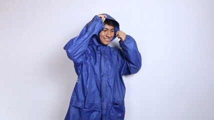 smiling asian young man wearing raincoat