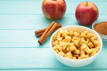 Apples with cinnamon on plate on blue background. Red apples with cinnamon sticks and star anise.