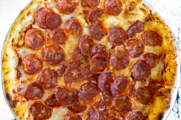 Close-up of sliced pizza with melted cheese triangles on a textured white background. Flat lay food photography