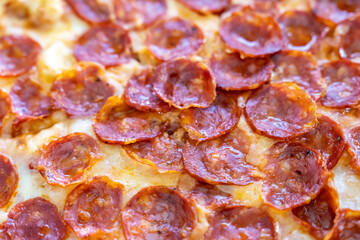 Close-up of sliced pizza with melted cheese triangles on a textured white background. Flat lay food photography