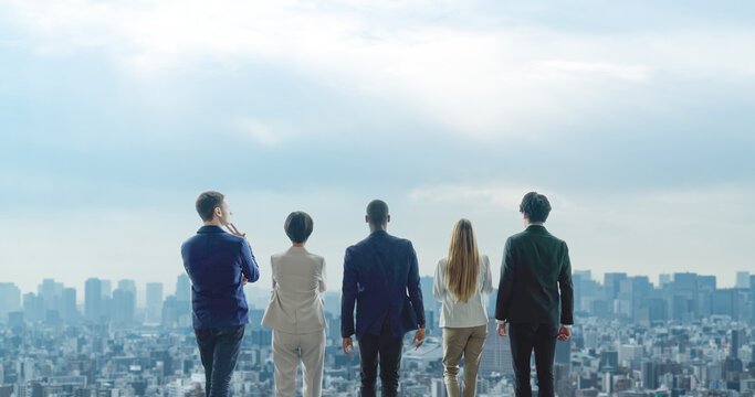 Back view of multinational people looking at the city. Global business concept.