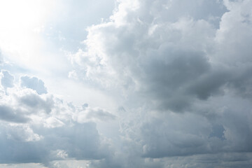 Fluffy white clouds drift across a clear blue sky, painting a beautiful summer day