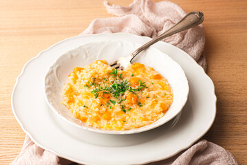 Risotto with pumpkin and Grana Padana cheese, cuisine of Northern Italy. Mantua, Mantovan pumpkin. Seasonal recipes of Italy, autumn and winter, front view