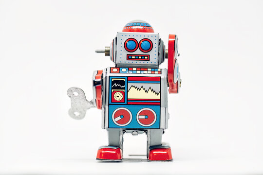 Classic tin toy robot standing on white background