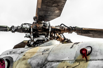 Military helicopter's rotor head and blades stand out against a sky,