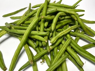 A vibrant pile of fresh green beans, just plucked from the garden, ready to add a burst of flavor isolated on white
