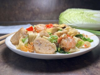 Spicy fried noodle with shrimp, chicken meat ball and vegetables. Thai style food.