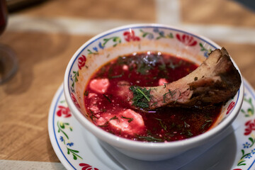 A delicious bowl of soup that contains a piece of meat in it