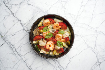 Seafood salad with shrimps, tomatoes, mushrooms , olives and herbs