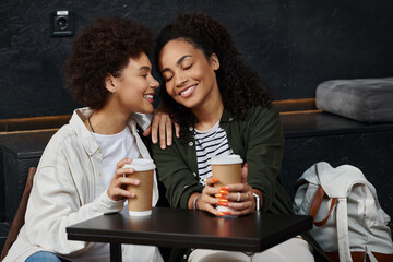 A happy couple warmly interacts at a hostel cafe, excited for their travel adventure together.