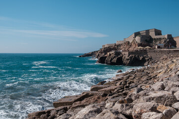 Waves crushing against cliff of city of Sete, France