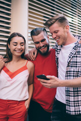 Friends browsing smartphone on street