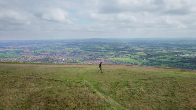 Backpacker hiker walking on the peak of Malvern Hills