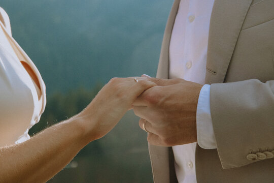 Close-up of a couple holding hands in an intimate moment, symbolizing love and commitment.