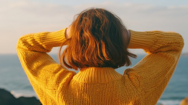 Lockige Br&uuml;nette im gelben Pullover genie&szlig;t K&uuml;stenblick f&uuml;r Fr&uuml;hlingsmarketing-Design