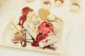 Delicious wedding dessert with ice cream, chocolate drizzle, and fruit topping, beautifully presented with heart-shaped decorations