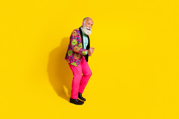 Full size photo of charismatic man dancing empty space wear pink trousers blazer isolated on yellow color background