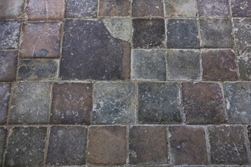 Closeup of a brick floor displaying a checkered pattern