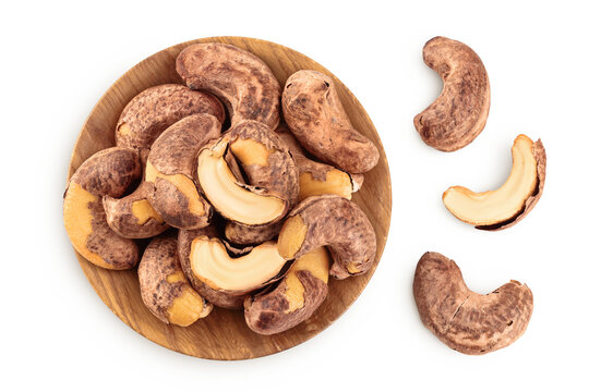 cashew nut with shell in wooden bowl isolated on white background. Top view. Flat lay
