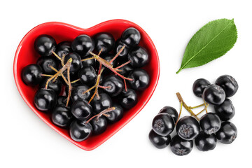 Chokeberry with leaf in a ceramic bowl isolated on white background. Black aronia. Top view. Flat lay