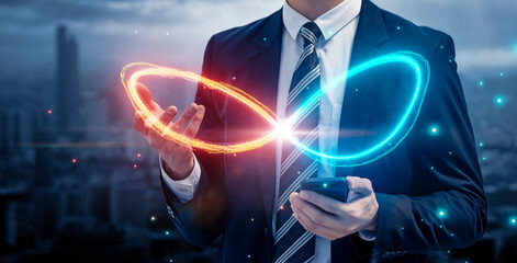 Businessman using mobile phone with infinity symbol connecting unlimited internet data usage 5G technology , limitless infinite data user storage cloud computing network security, city blue background