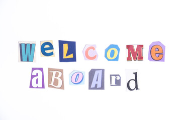 Welcome symbol. Concept words Welcome Aboard isolated on clean white background in fun cut out newspaper style typescript. 