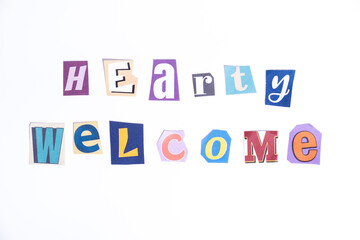 Welcome symbol. Concept words Hearty Welcome isolated on clean white background in fun cut out newspaper style typescript. 