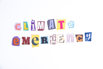 Phrase Climate Emergency spelled in cut out newspaper style typography isolated on white background.