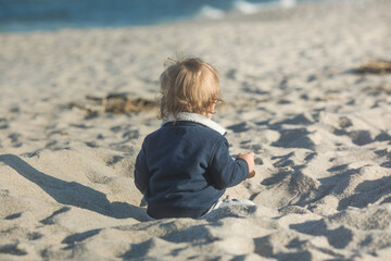 Little baby boy playing on  ocean beach.  Toddler kid during family sea vacation. Summer water fun.