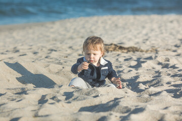 Little baby boy playing on  ocean beach.  Toddler kid during family sea vacation. Summer water fun.