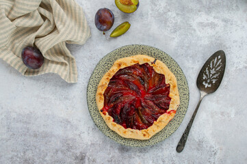 Homemade Galette with plum and honey on a light background. Summer pastry. Shortcrust dough. Zwetschgenkuchen.