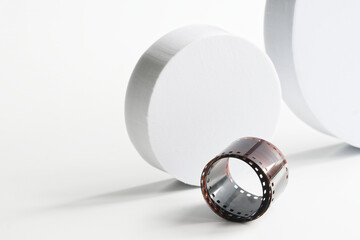 Developed photographic film on a white background next to white circles. Retro and futurism. Past...