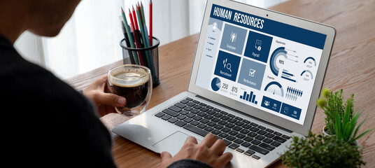 Human resources management software on computer screen helping human resources employee to manage...