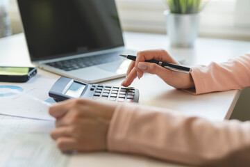 Deduction planning, debt asian young woman  hand using calculator to calculating money balance from bill and income, cost budget expenses for pay money form personal individual on table at home.