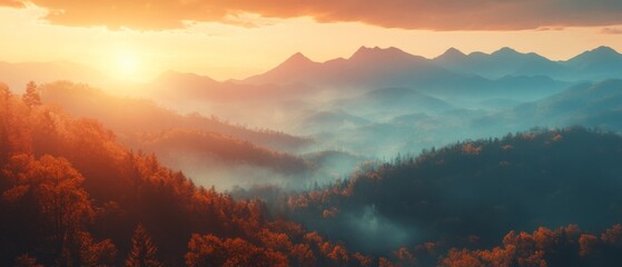 Fototapeta premium A misty mountain range during autumn with golden leaves, the sun rising behind the peaks